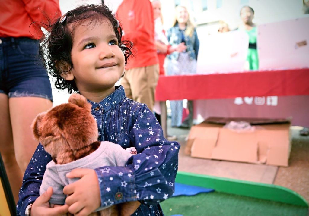 little girl clutching debate teddy bear