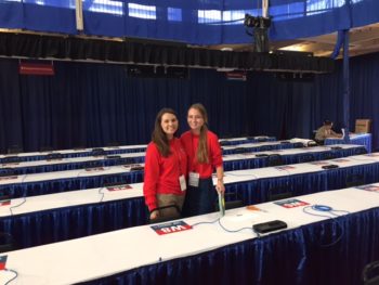 Bru Hickey (left) and Ellen Birch tape signs in the media filing center. Their volunteer jobs with the Commission on Presidential Debates are giving them a behind-the-scenes look during debate preparations.